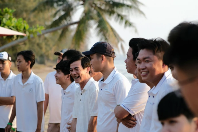 a group of men standing next to each other on a beach